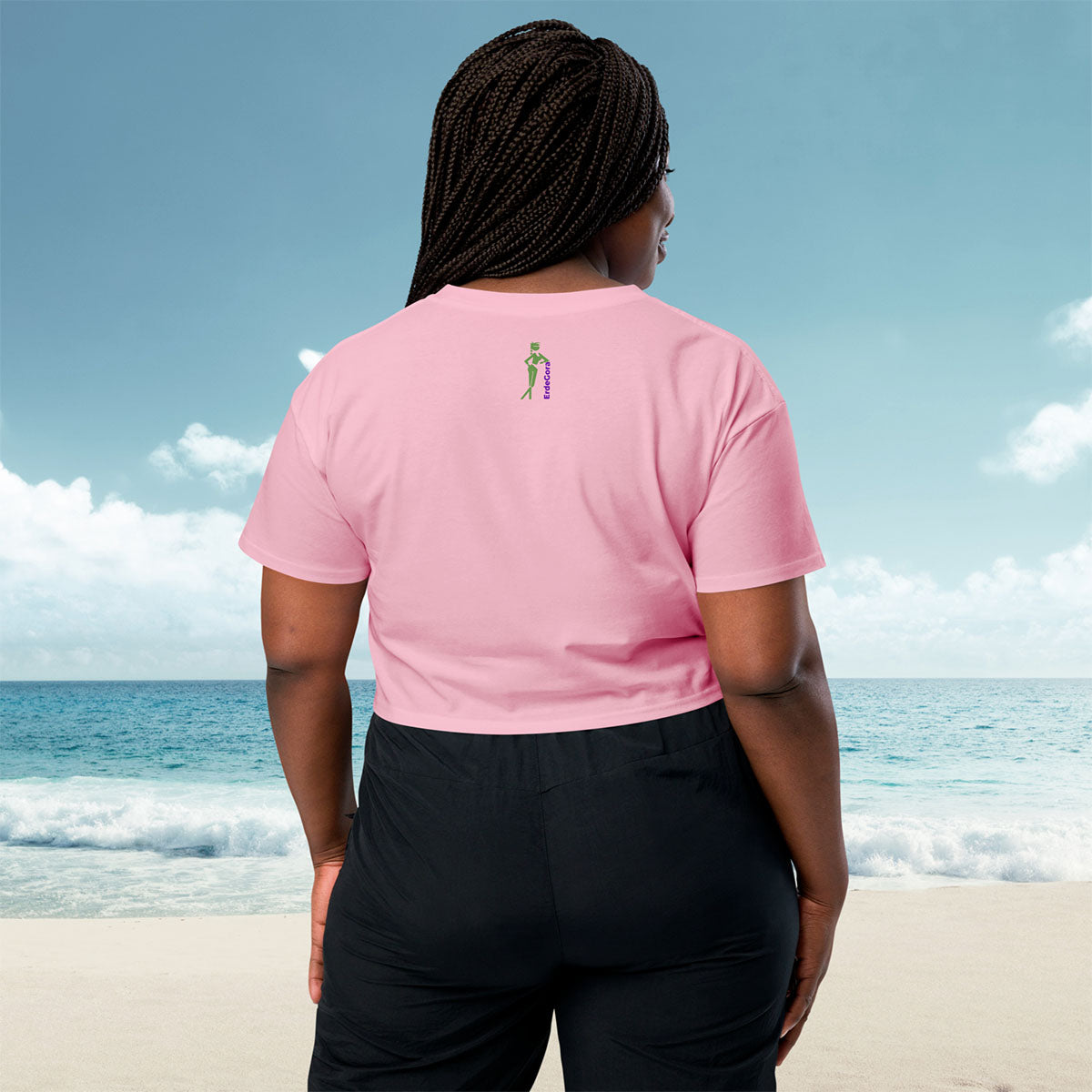 Person wearing a pink crop top erdegora  logo on the beach, back view