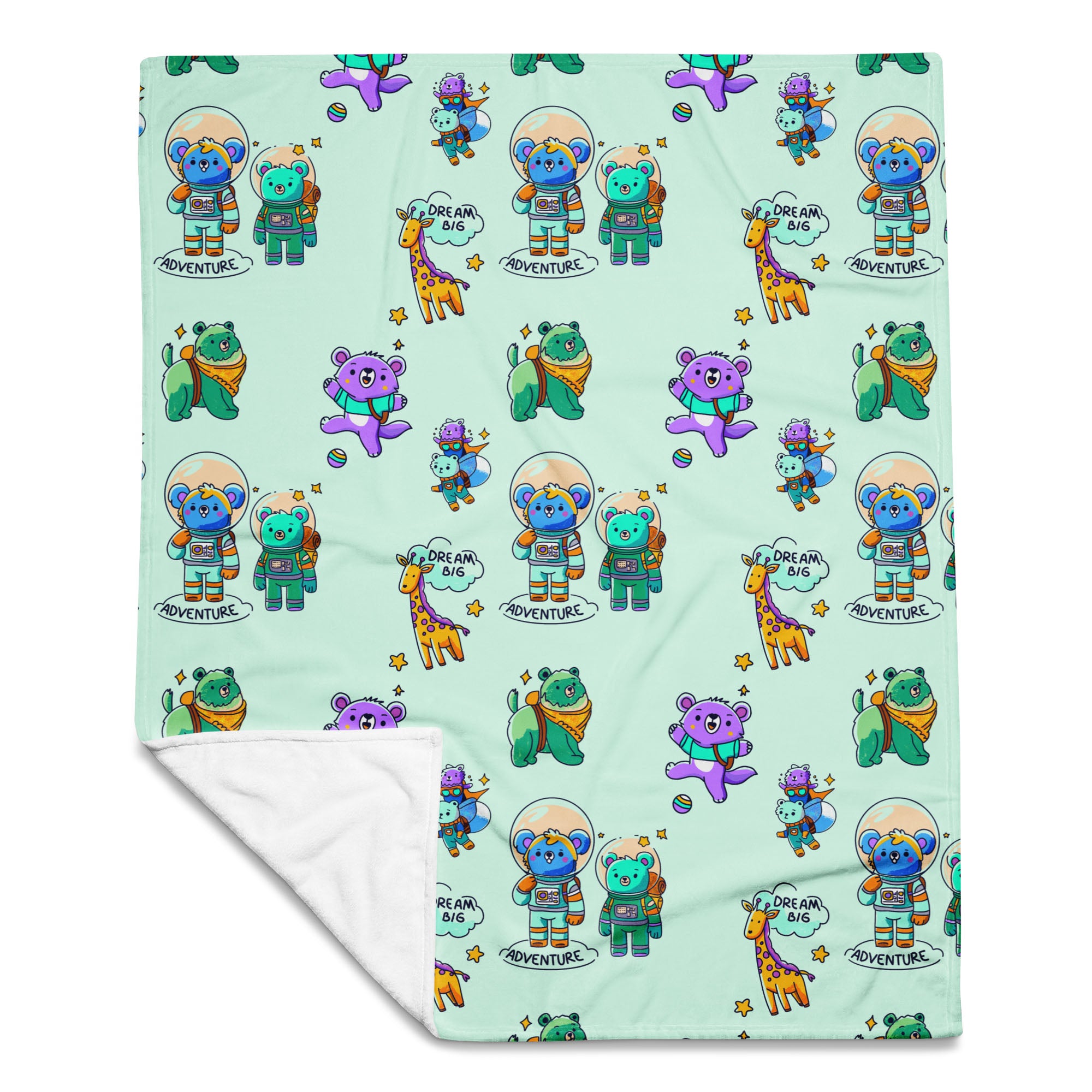 Flat-lay of a mint-green throw blanket printed with cute cartoon astronaut bears, koalas, giraffes and “Dream Big Adventure” text, with one corner folded to reveal the soft white fleece backing.