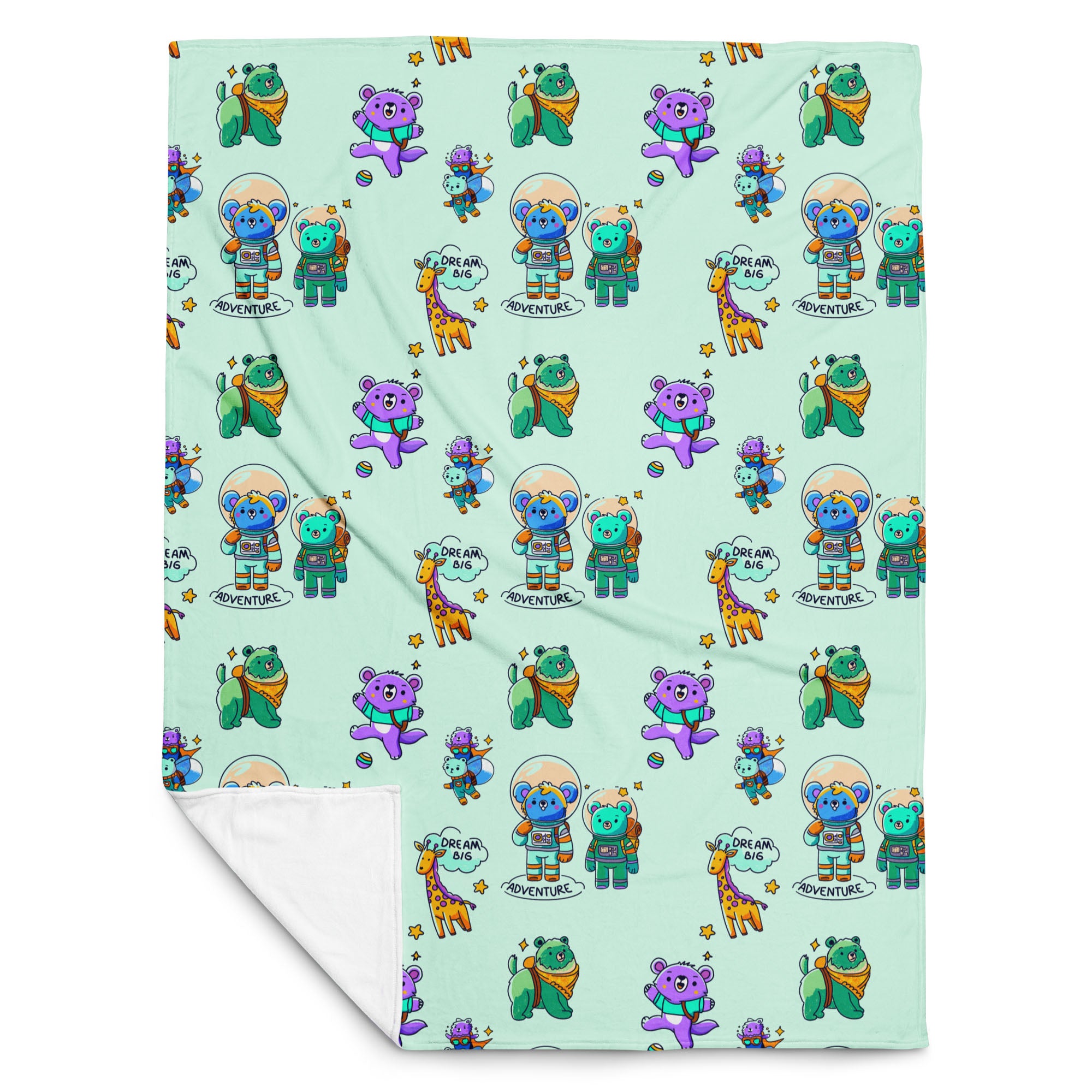 Flat-lay of a mint-green throw blanket printed with cute cartoon astronaut bears, koalas, giraffes and “Dream Big Adventure” text, with one corner folded to reveal the soft white fleece backing.