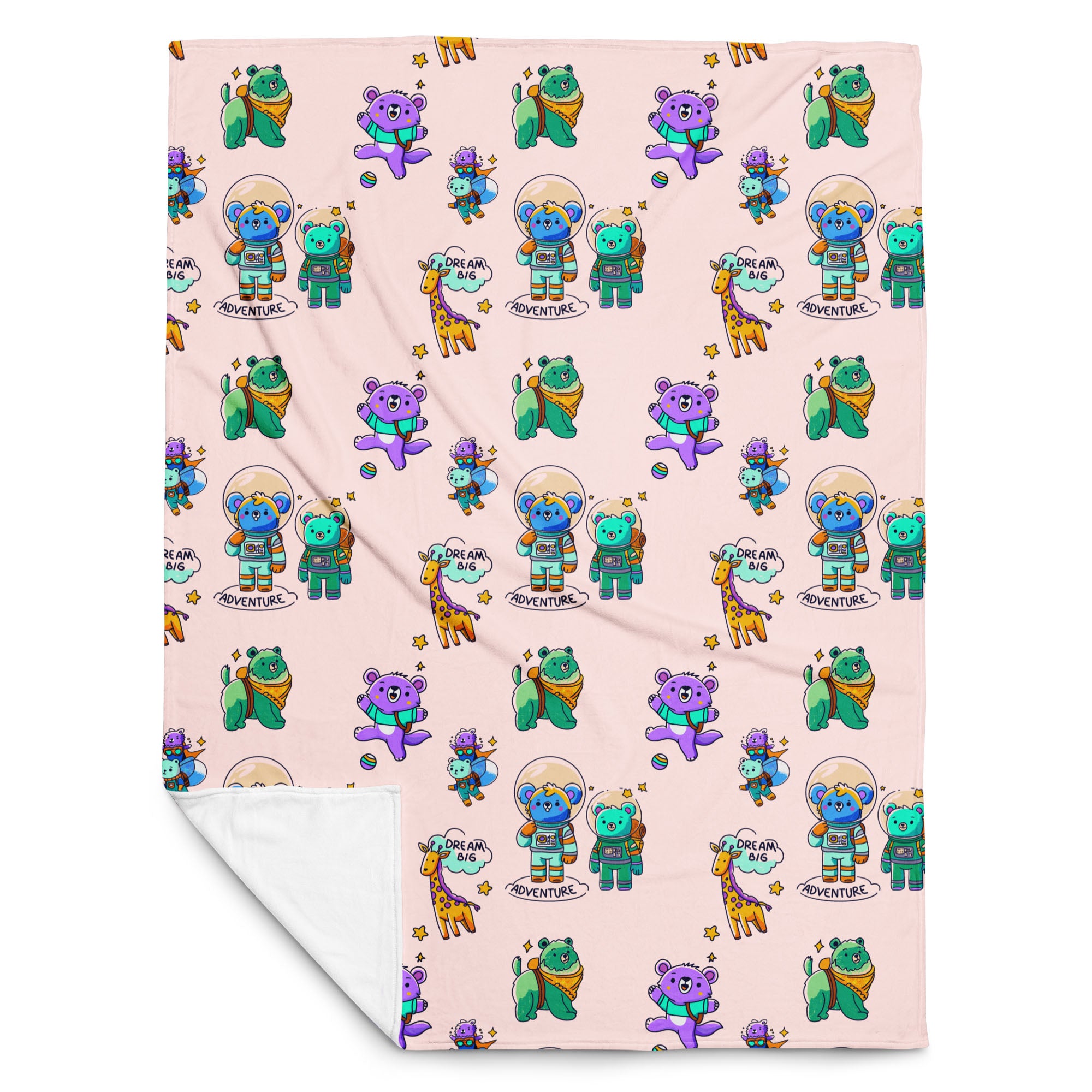 Flat-lay of a pale pink throw blanket printed with cute cartoon astronaut bears, koalas, giraffes and “Dream Big Adventure” text, with one corner folded to reveal the soft white fleece backing.