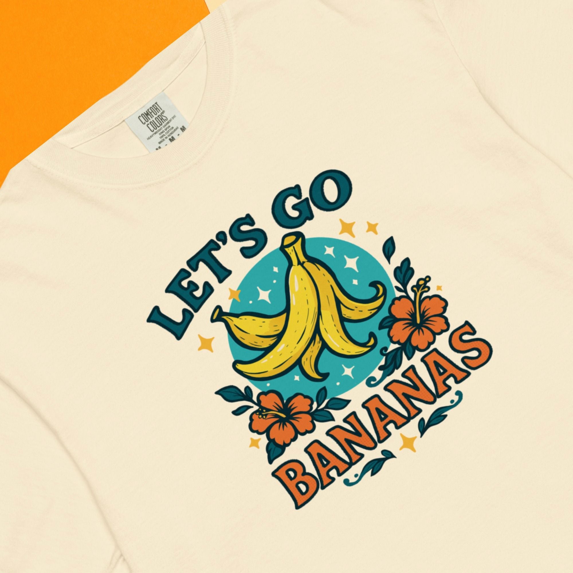 Beige t-shirt with 'Let's Go Bananas' graphic design featuring bananas and flowers on a matching background.