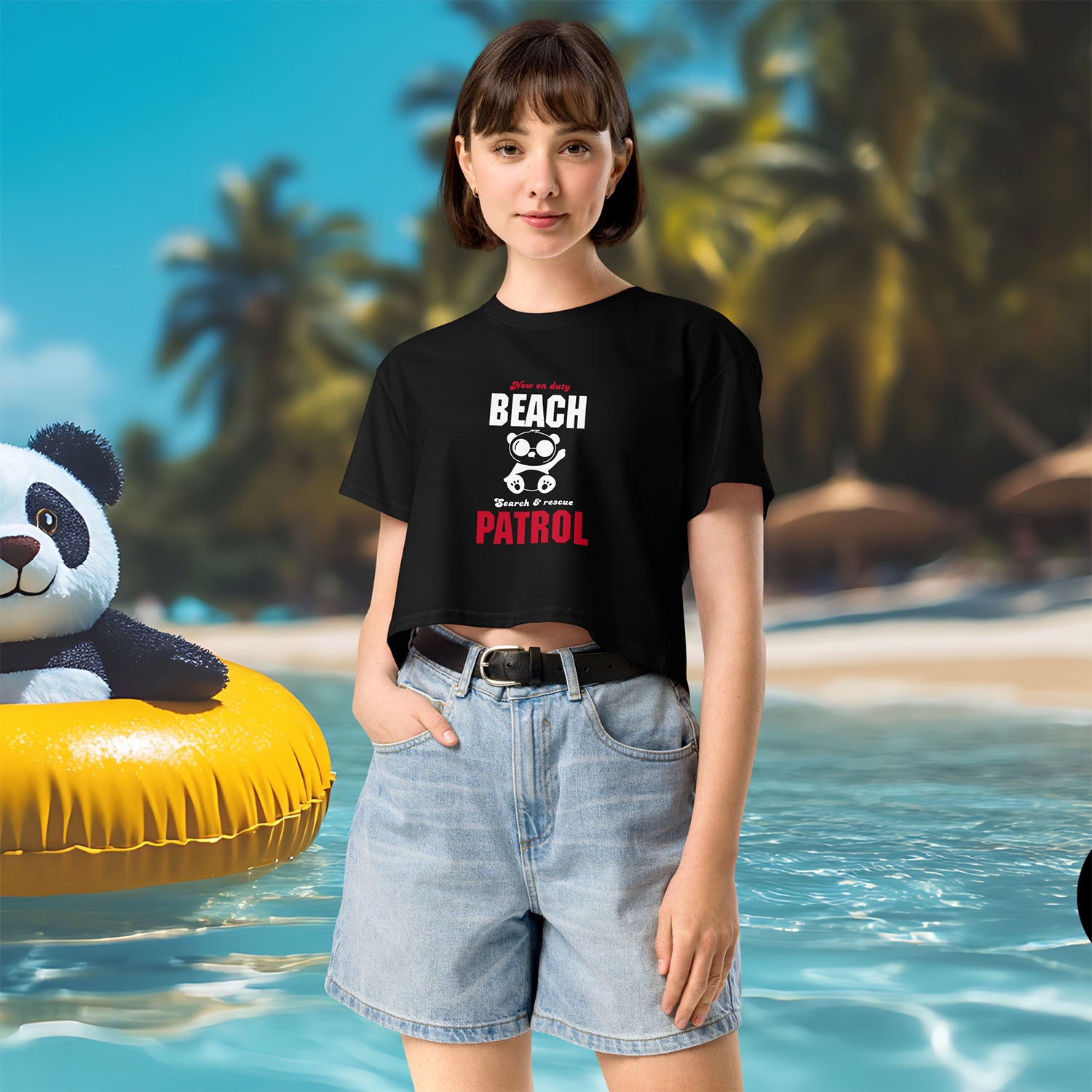 Person wearing a black t-shirt with 'Beach Patrol' text, standing on a beach with a panda k floaty.