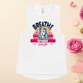 A white muscle tank top with the text 'BREATHE TRUST LET GO' and a graphic print on the front, displayed on a flat surface with decorative flowers around it.