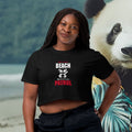 Woman wearing a black t-shirt with 'Beach Patrol' text, standing on a beach with a panda illustration.