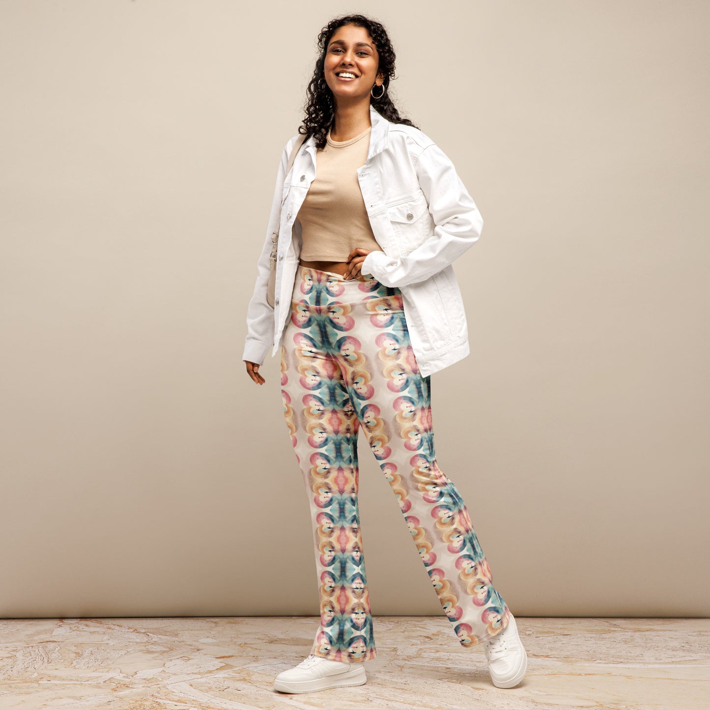 High-rise flared leggings with a colorful heart unity pattern, featuring a high waist and flared bottoms, worn by a smiling model.