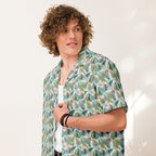 Person wearing Unisex Button Shirt in Jungle Fever, featuring a lush tropical print, lightweight and moisture-wicking material, perfect for hot summer days.