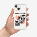 Phone case with a cat illustration and text held by a hand on a white background