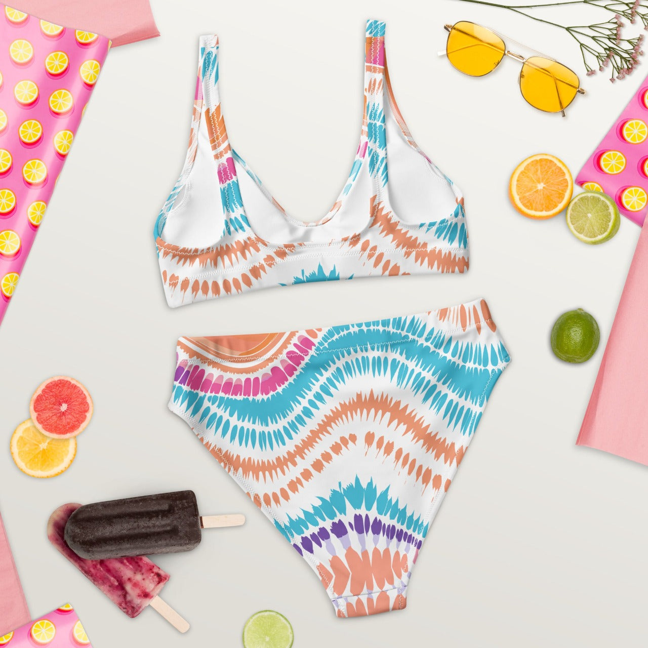 Flat lay back view of ErdeGora’s Crush Waves bikini featuring a high-waisted bottom and a matching V-neck top, both crafted from sustainable recycled materials and adorned with a dynamic, multicolored wave-inspired print.