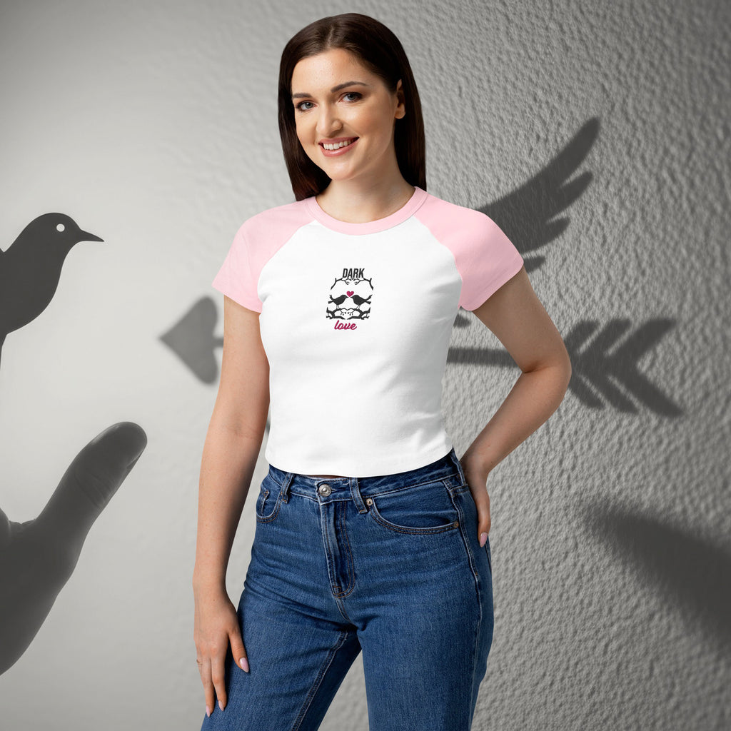 Woman wearing ErdeGora micro rib raglan baby tee front view, white with pink sleeves and embroidered Dark Love birds with heart
