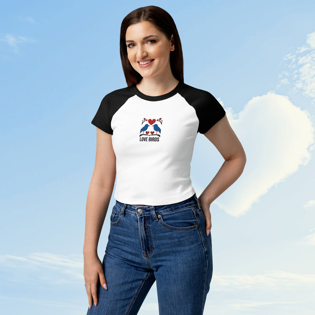 Woman wearing a white and black baseball shirt with a graphic design against a blue sky.