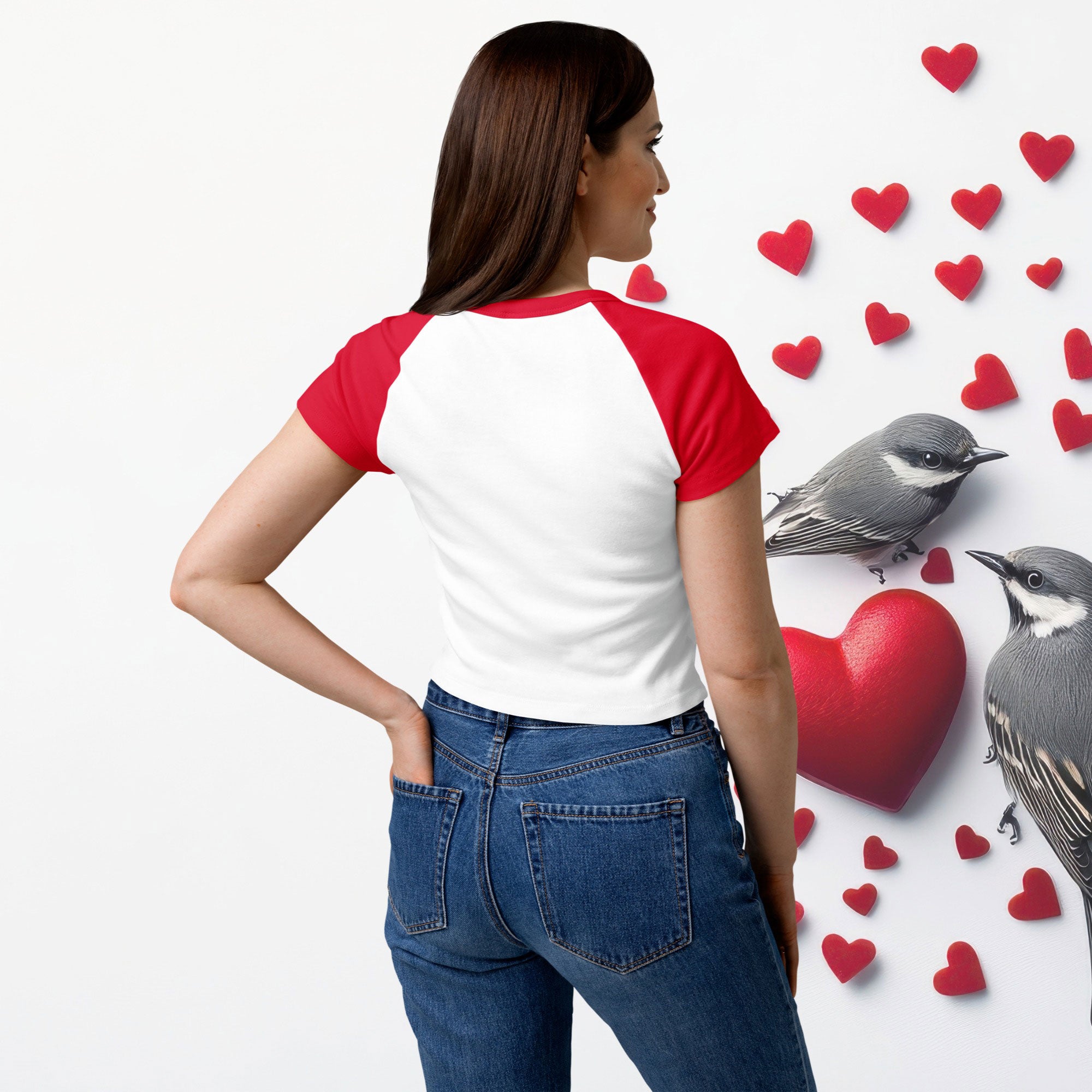 Woman wearing a red and white shirt with blue jeans, standing next to a heart and birds illustration.