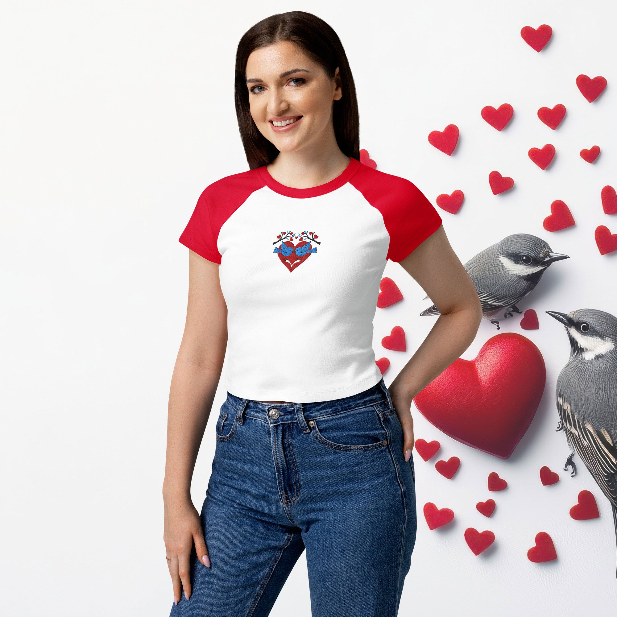 Woman wearing a red and white baseball shirt with a heart design, standing against a white background with hearts and birds.