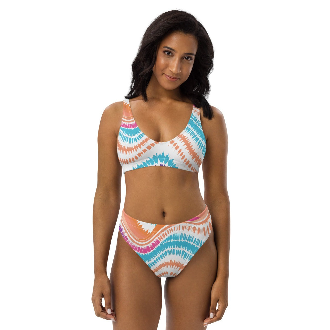 Female model wearing ErdeGora’s white Crush Waves bikini, front view, with a high-waisted bottom and V-neck top featuring a colorful wave print.