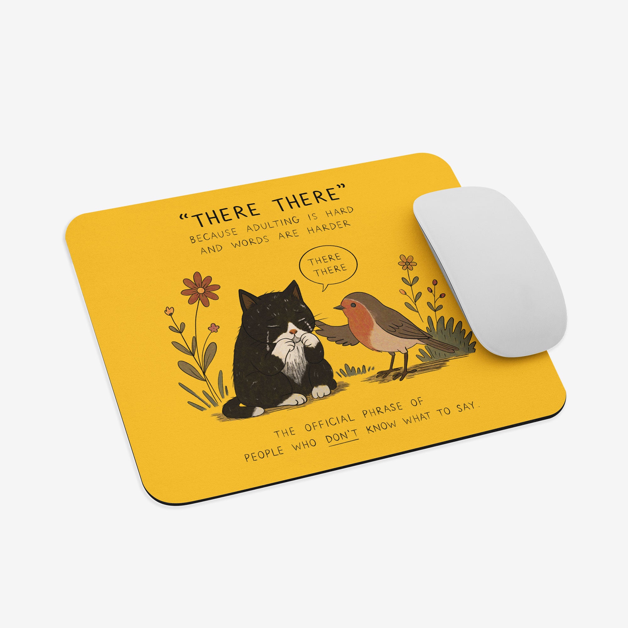 A yellow mousepad with a humorous illustration of a black cat and a robin bird, accompanied by a white computer mouse on a light gray background.