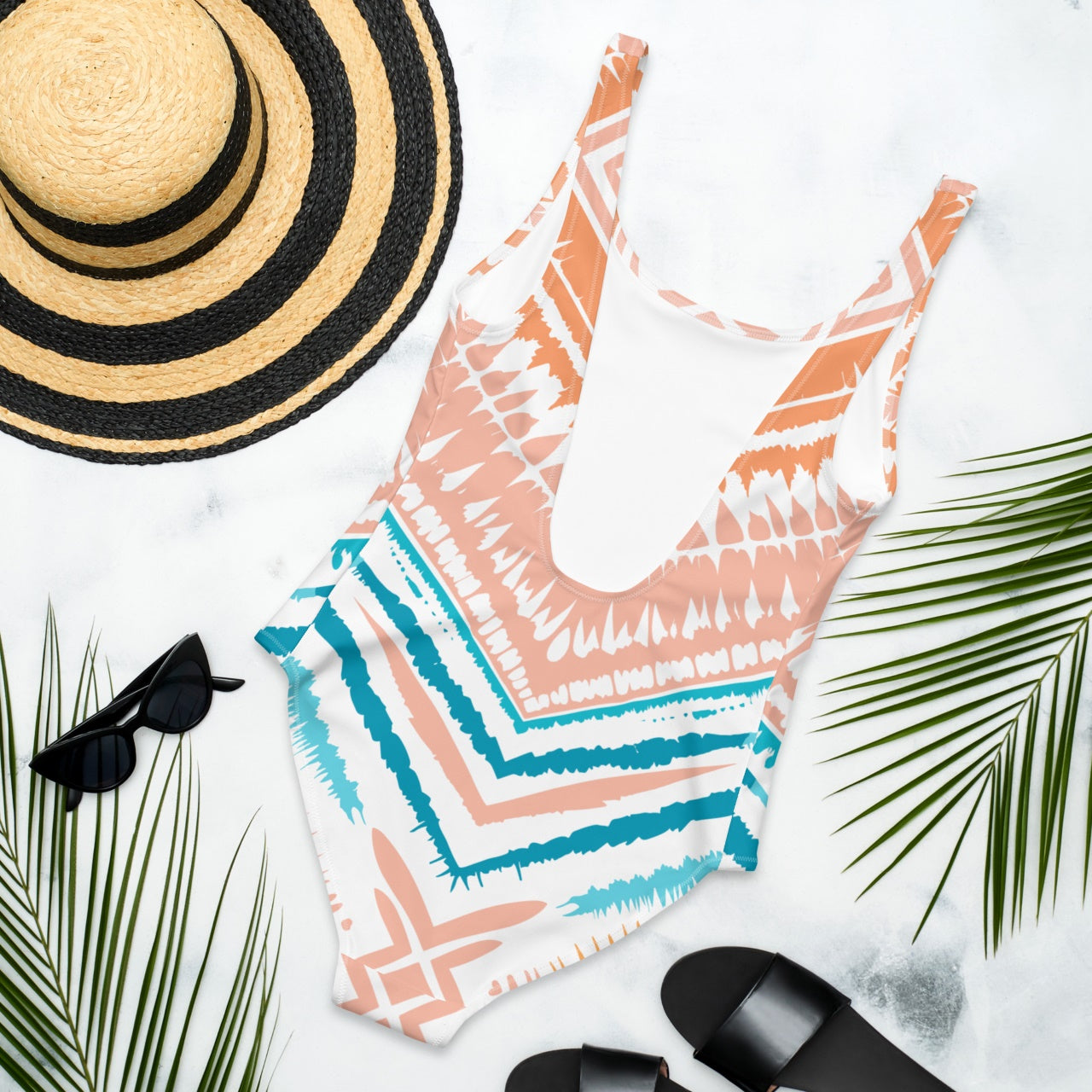 Back view of Peachy Blues Aztec Charm one-piece swimsuit laying flat, showcasing the eco-friendly fabric and high-waist cut.