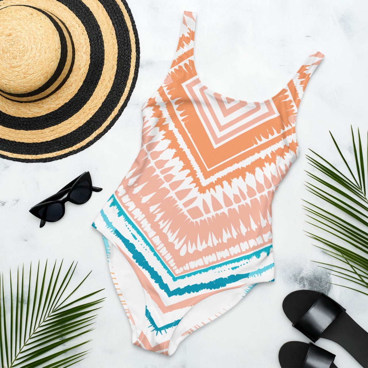 Front view of Peachy Blues Aztec Charm one-piece swimsuit laying flat, highlighting the intricate peach and blue Aztec pattern.