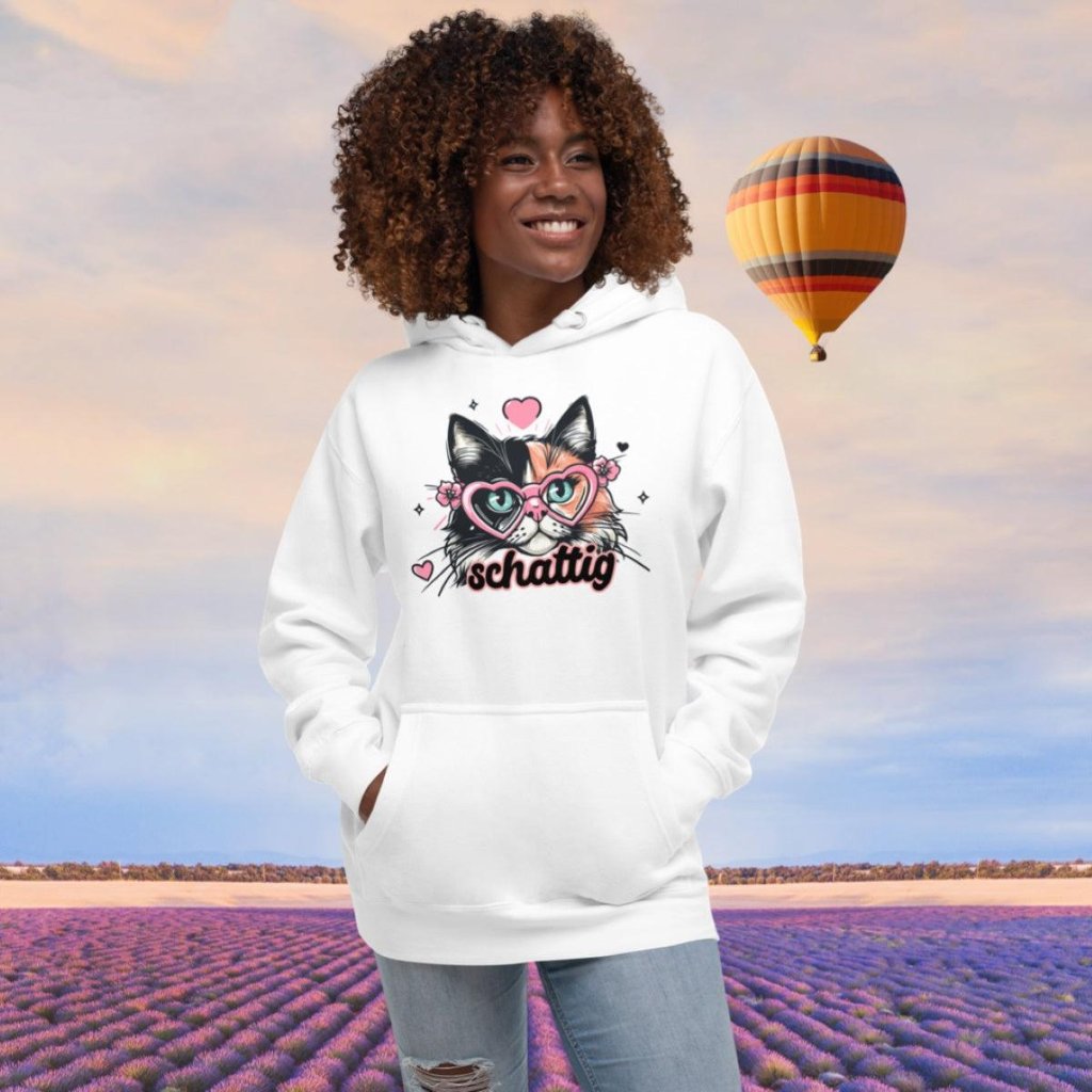 Model wearing a white Erdegora premium hoodie featuring the "Schattig" cat design with heart-shaped glasses and floral accents.