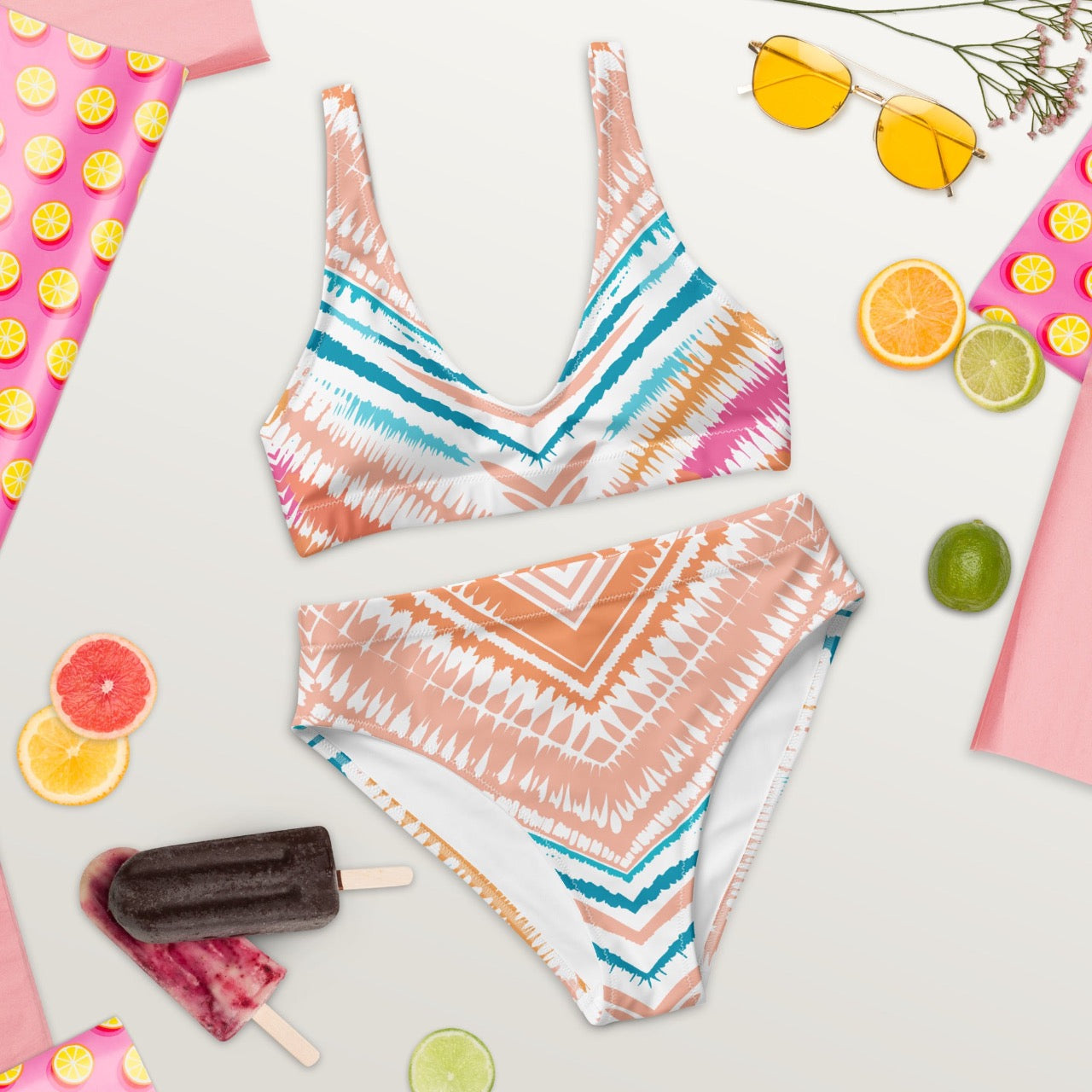 Flat lay front view of ErdeGora Recycled High-Waist Bikini Peachy Blues Tribal Splash, featuring a high-waisted bottom and matching top with a vibrant tribal print