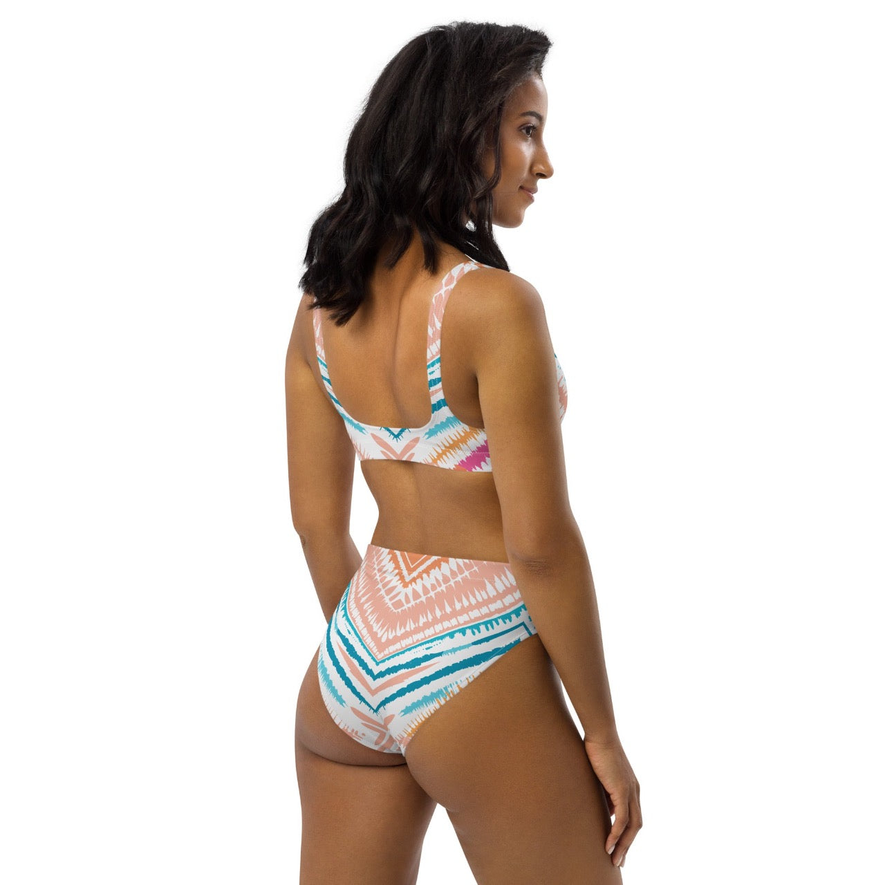 Female model wearing ErdeGora Recycled High-Waist Bikini Peachy Blues Tribal Splash, back-side view, featuring the flattering high-waisted bottom and vibrant tribal print top.