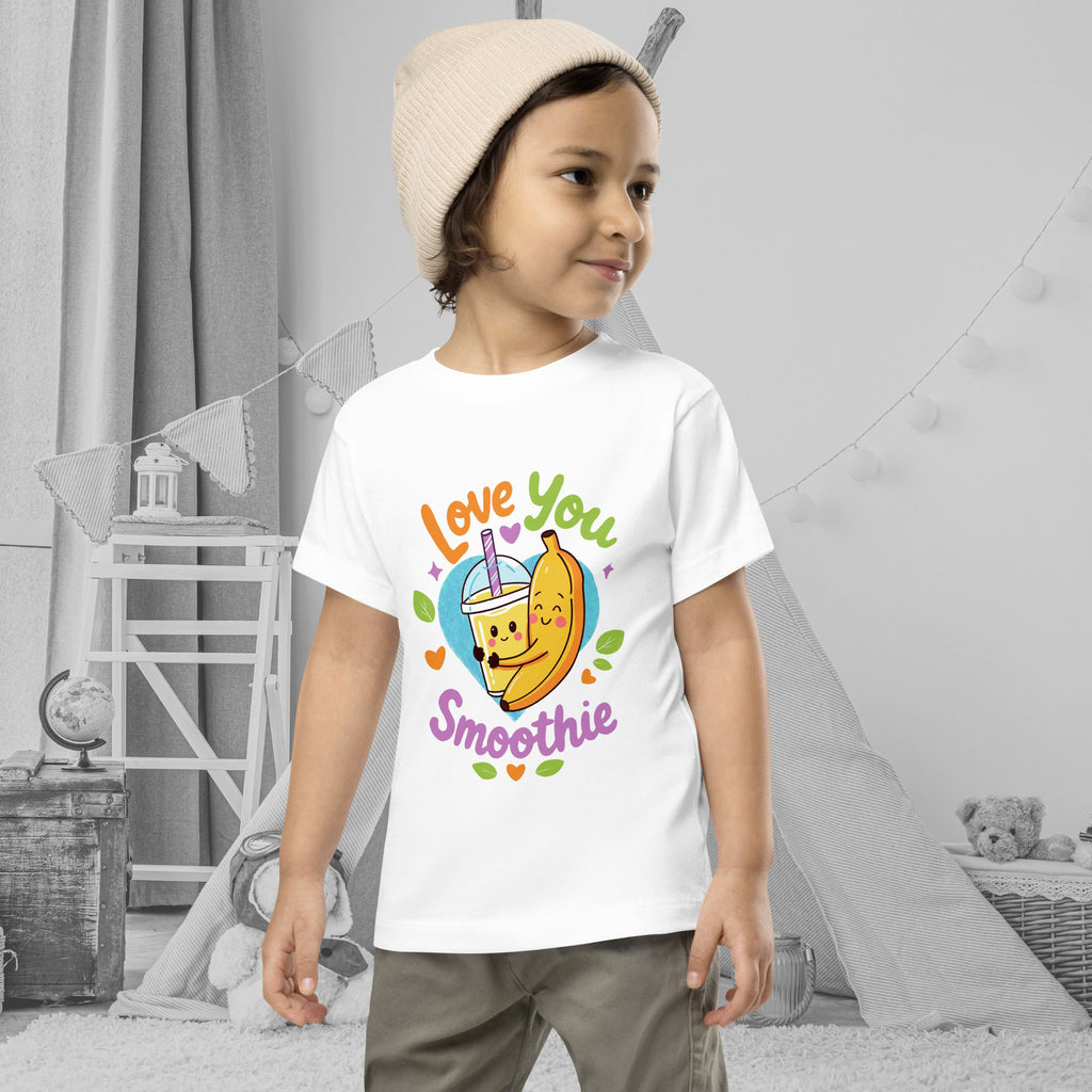Child wearing a white t-shirt with a colorful graphic and text in a room.