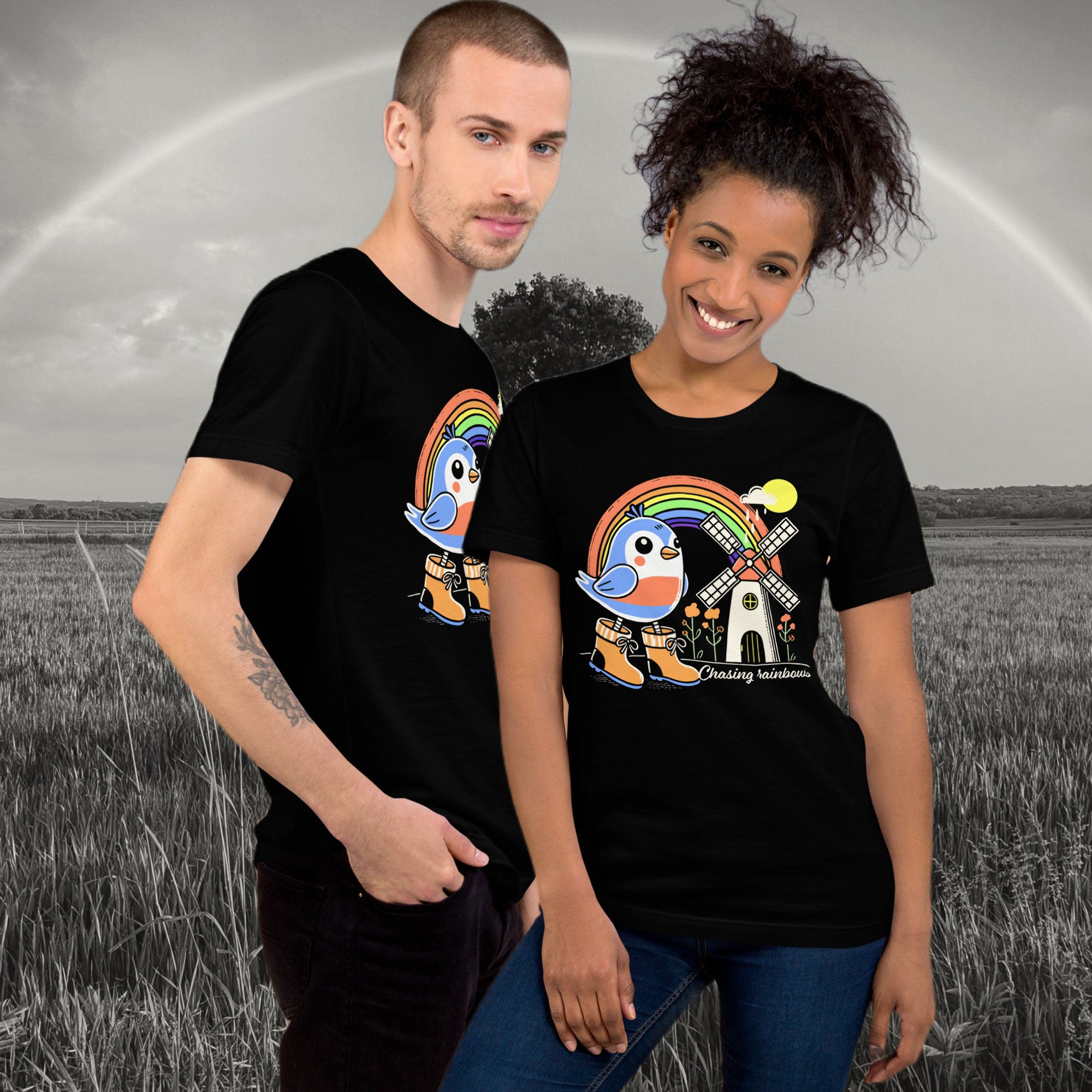 Two people wearing black t-shirts with a colorful graphic design of a robin bird and rainbow, text chasing rainbows.