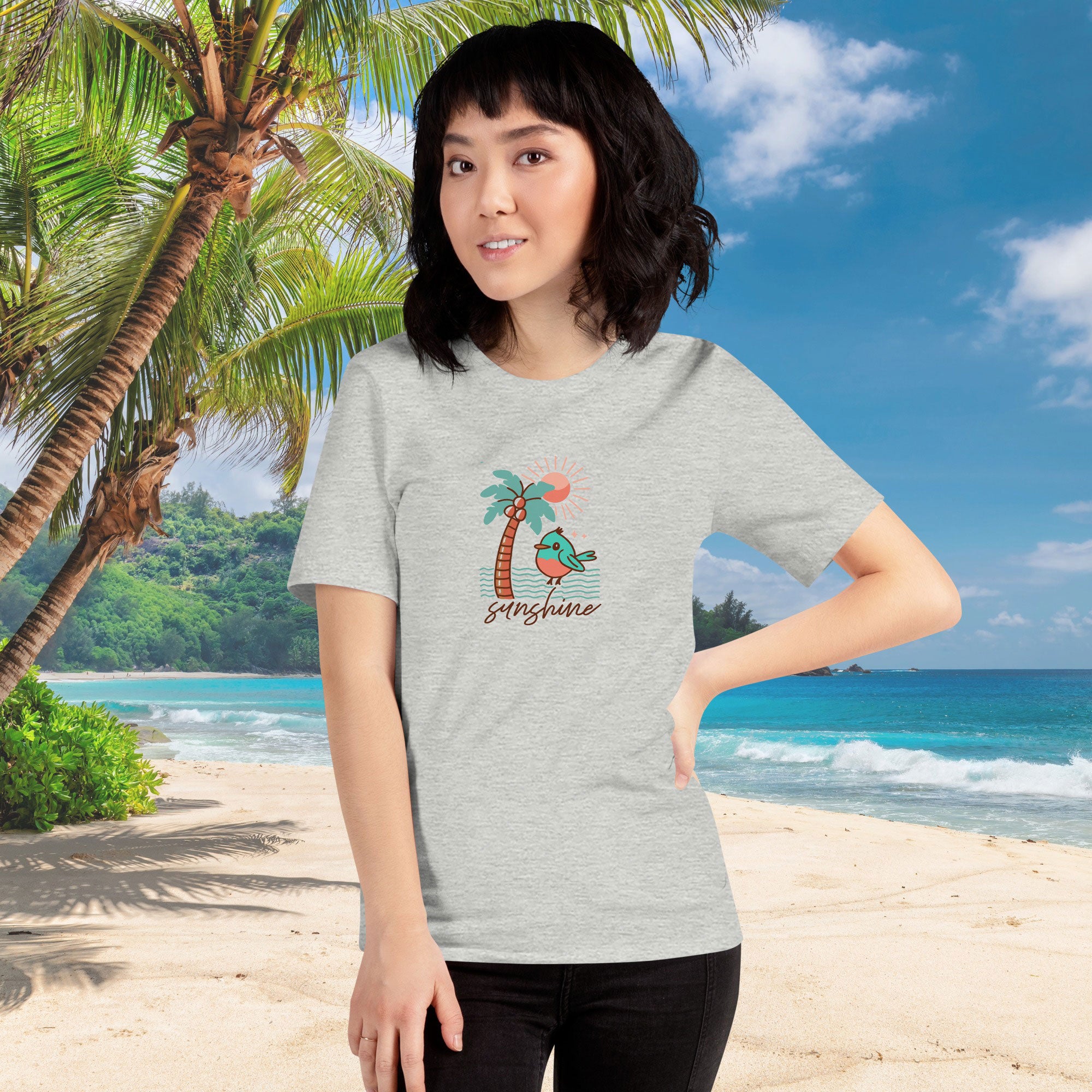 Woman wearing a gray t-shirt with a palm tree design on a beach background