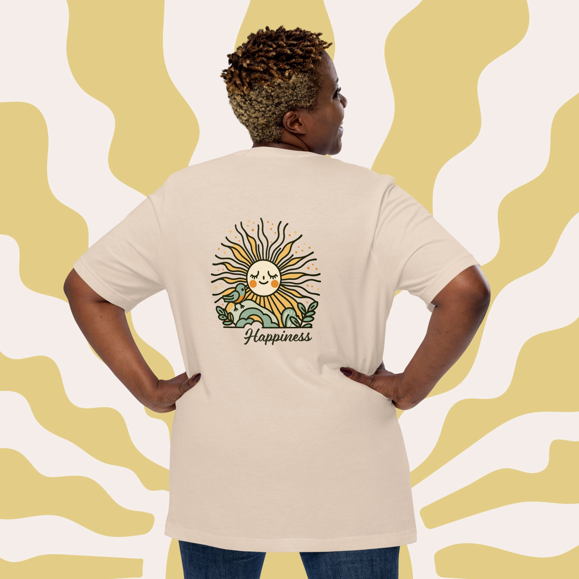 Person wearing a beige t-shirt with a sun design and 'Happiness' text on the back, against a yellow wavy patterned background.
