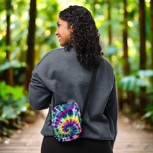 Woman wearing a Utility Crossbody Bag in Tie-Dye Fusion, featuring a vibrant tie-dye pattern, adjustable strap, and roomy pockets, perfect for any adventure.