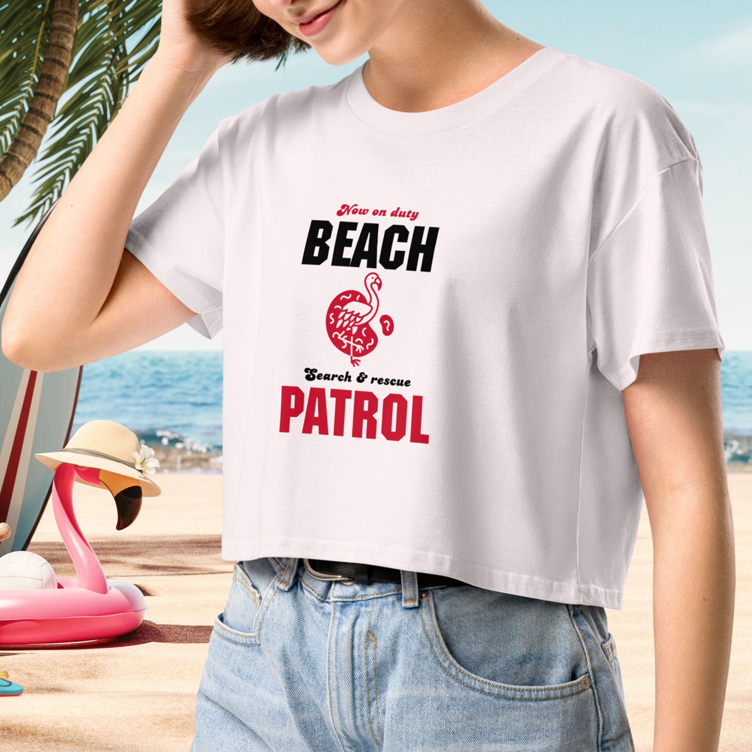 Close-up of women’s Y2K-style crop tee in Orchid, featuring a retro ‘Beach Patrol’ flamingo graphic on the front. Relaxed fit with short sleeves, styled for a fun and casual summer look.